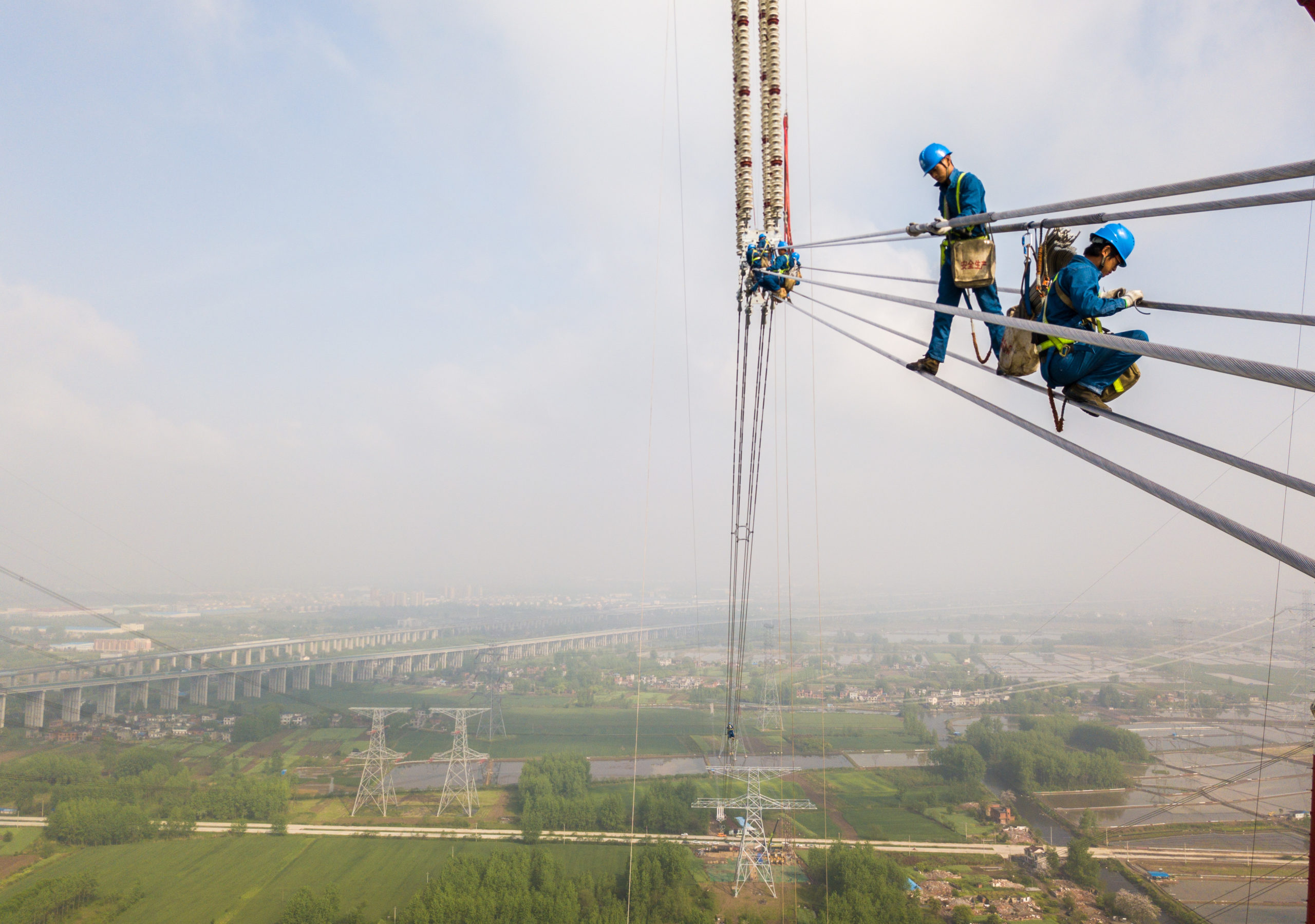 Yläilmoissa taiteilevat työntekijät viimeistelivät Changji-Guquan-korkeajännitelinjan osaa Anhuin maakunnassa keväällä 2018. Kuva: Shutterstock/All Over Press