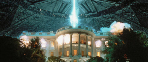 Ufo laskeutuu valkoiseen talon ylle.