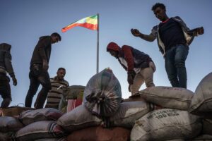 Miehet lastaavat säkkejä Etiopian lipun alla.