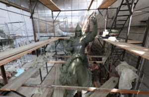 Rakennustelineiden sisäpuolella mies tekee patsasta hevosesta ja ratsastajasta, joka kuvaa Novgorodin ruhtinas Aleksanteria.