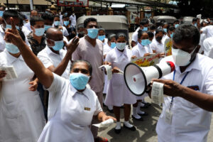 Sairaalan henkilökunta protestoi valkotakit päällään Sri Lankassa.