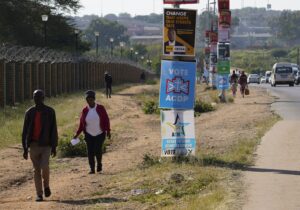 Ihmiset kävelevät tienvarteen pystytettyjen vaalimainosten ohi Pretoriassa.