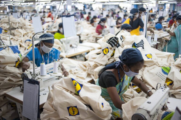 Työntekjät ompelevat Lidlin kestokasseja intialaisessa tehtaassa.